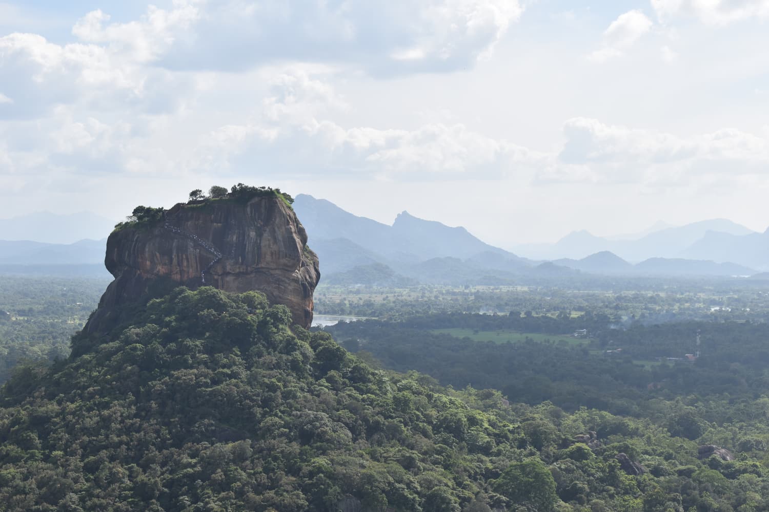 View from Pidurangala summit across the jungle to Sigiriya rock and the hills beyond